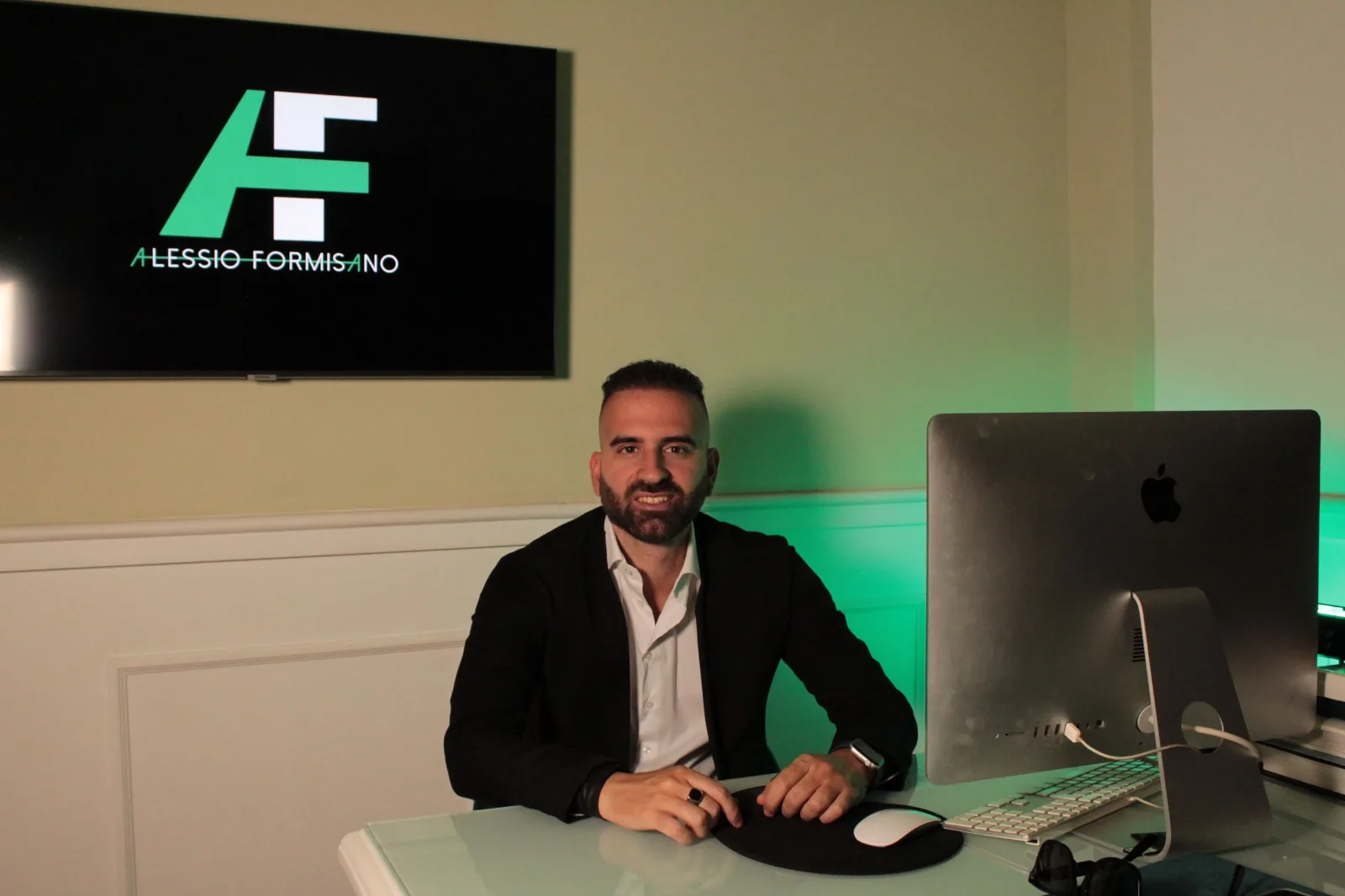 Alessio Formisano seduto alla scrivania del suo studio